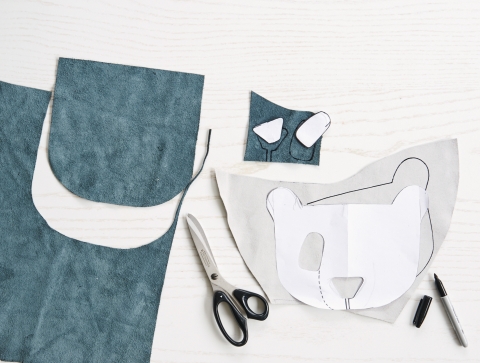 Bärengesicht mit Filzstift nachzeichnen. Leder zuschneiden: Tasche (Lederstück: 21x42cm), Deckel, Bärenkopf, Augen und Nase.