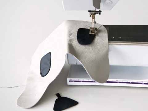 Augenteile und Nase annähen. Der entstandene Bärenkopf wird am Deckel angebracht – der Kante entlang absteppen.