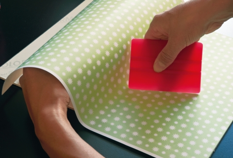 Mit Schleifpapier Holzhärchen der Weinkiste abschleifen und weiss streichen. Die Kunststoffplatte (Forex) als Schiebetür auf Mass zuschneiden und mit doppelseitiger Klebefolie überziehen. Geschenkpapier aufziehen – Tipp: mit Acryllack lackieren.